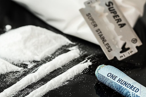 Ein Kokainsüchtiger hat Kokain in Linien aufgeteilt und ist bereit, es zu schnupfen.